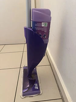 A purple bottle of the Flash mop cleaning solution attached to the mop